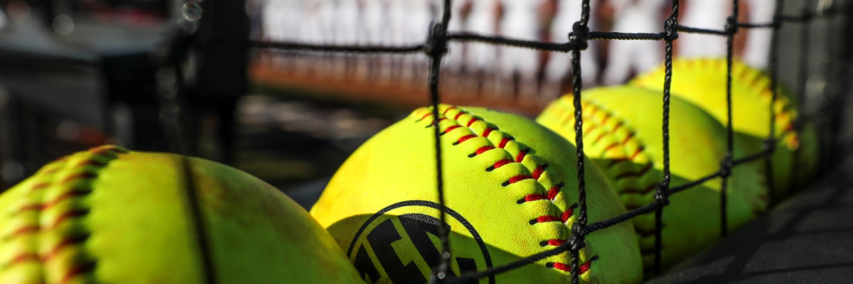 Softballs lined up along a net at a Mississippi State softball game.